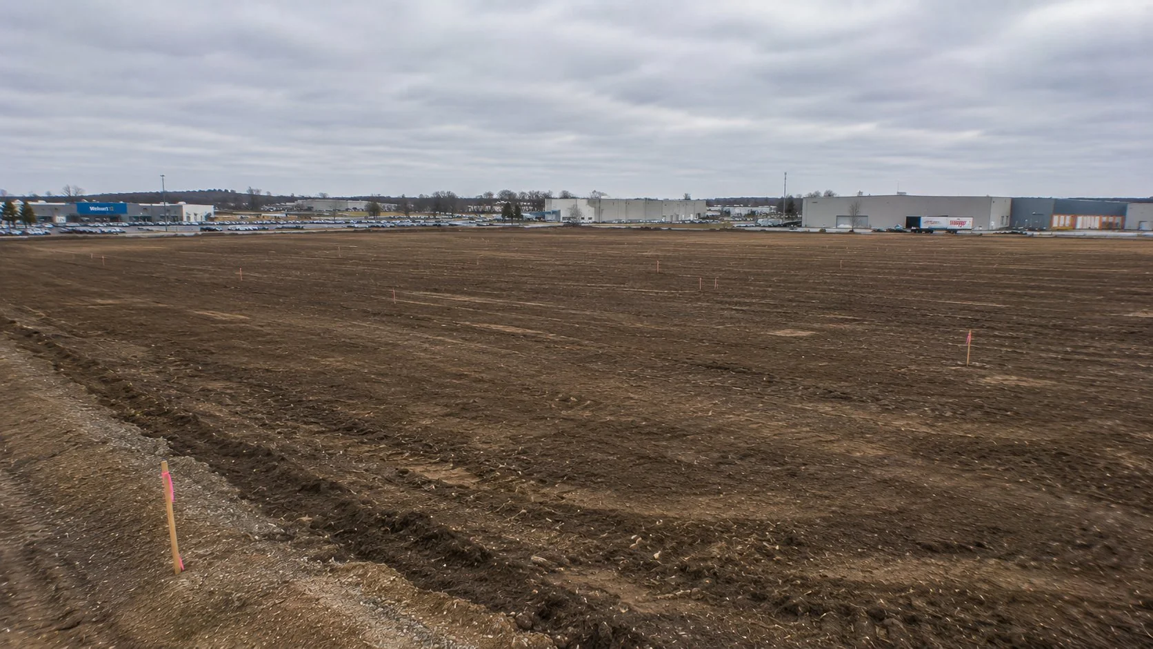 Cleared commercial lot in Central Ohio ready for development with survey stakes visible
