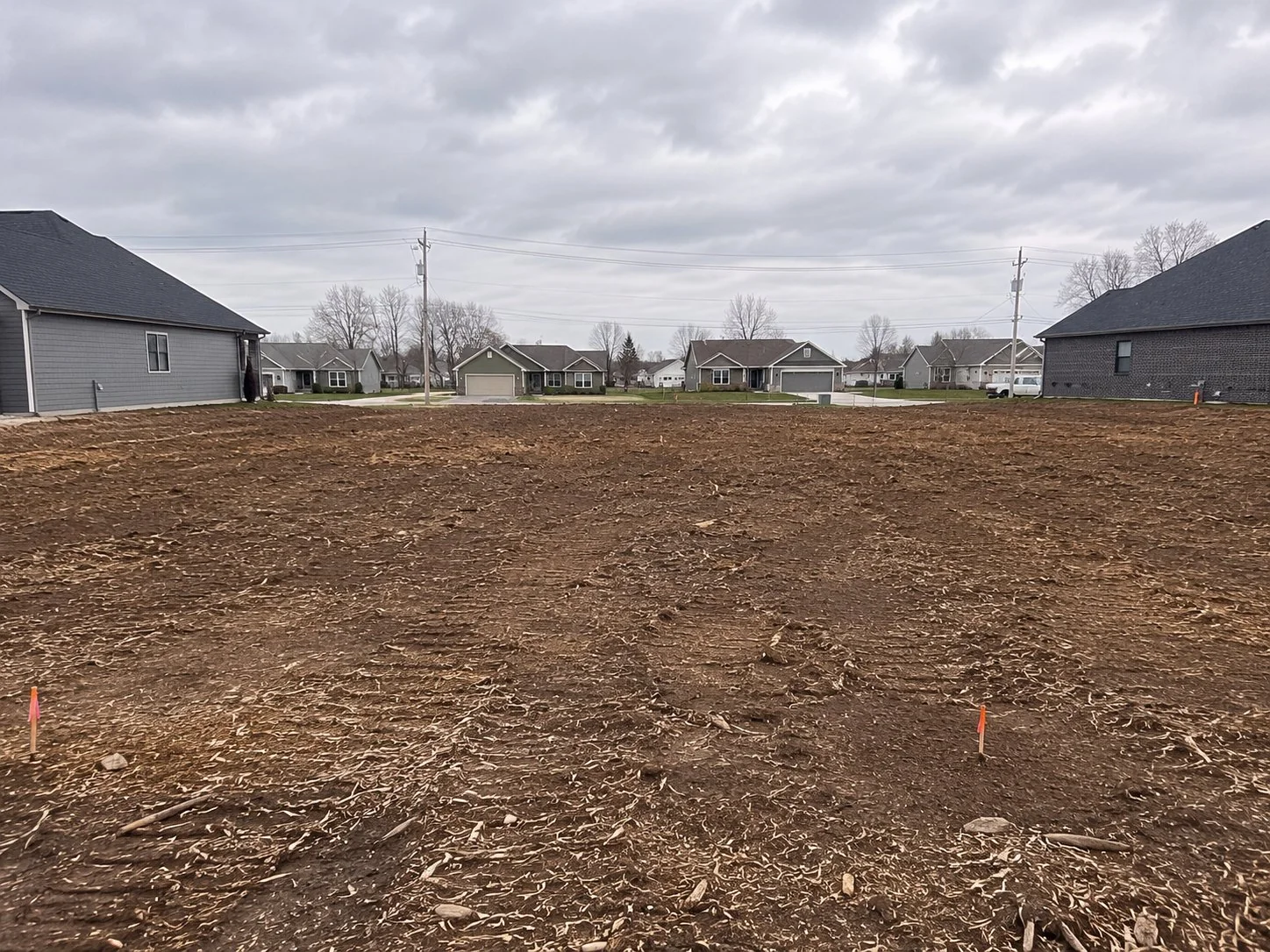 Cleared residential lot in Central Ohio suburban neighborhood ready for foundation work